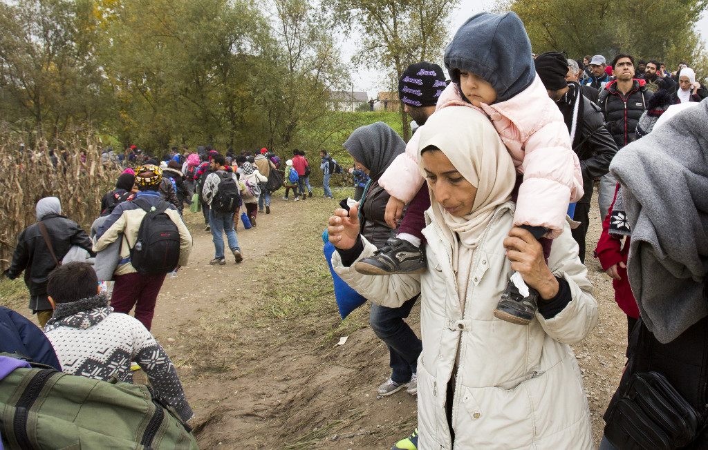 Människor på flykt får hjälp över gränsen mellan Kroatien och Slovenien. Kanske kommer några av dem till Sverige. Kommer de till respekt och trygghet eller till en osäker framtid? Foto: Darko Bendic/AP/TT