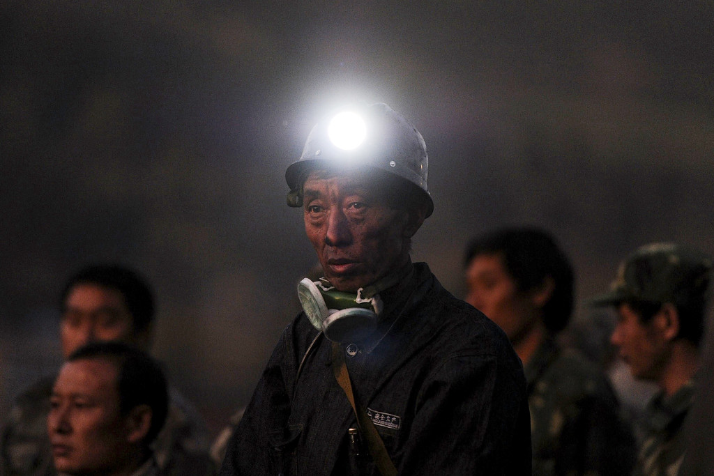 En gruvarbetare står och väntar på besked efter en gasolycka i Sizhuanggruvan, Kina, som dödade 20 och stängde in 23 personer 2011. Det ständiga osynliga hotet från den explosiva gasen i kolgruvorna får i Georges Didi-Hubermans bok symbolisera svårigheten att se katastrofen innan den inträffar. Foto: AP/TT