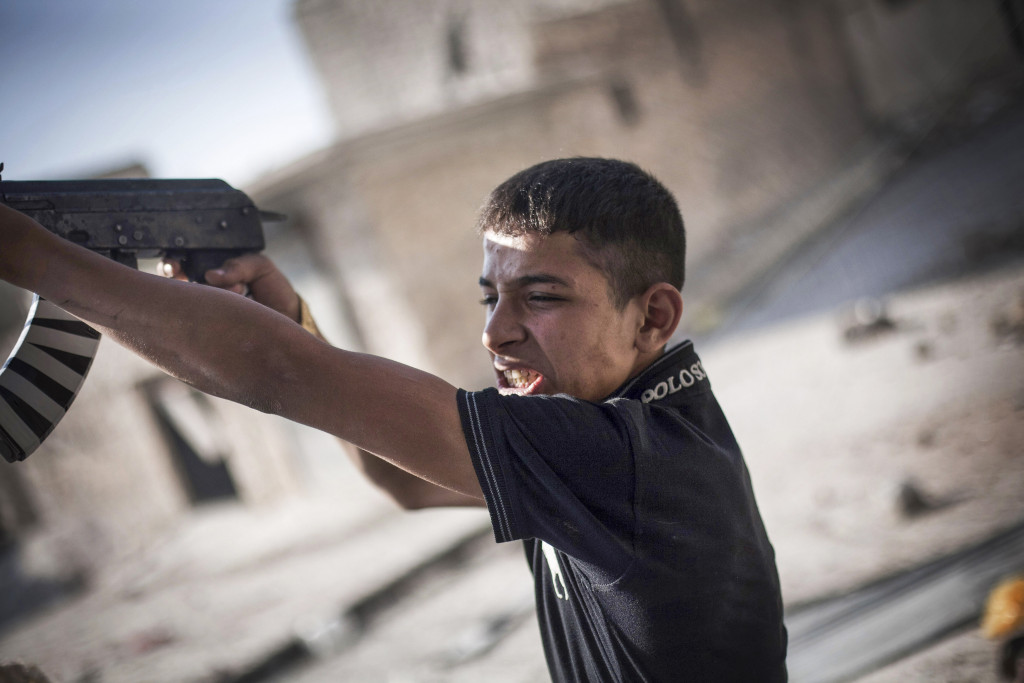 En FSA-soldat skjuter mot syriska arméns positioner i Amaryia- distriktet i Aleppo, september 2012. Foto: Manu Brabo/AP Photo/TT