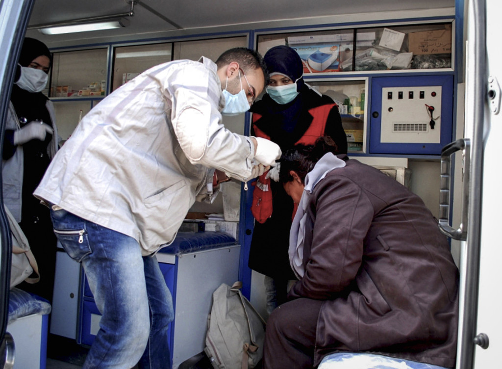 En skadad syrisk kvinna får vård i en ambulans efter att en bilbomb exploderat i byn al-Kaffat i Hamaprovinsen, januari 2013. Foto: AP Photo/SANA/TT.