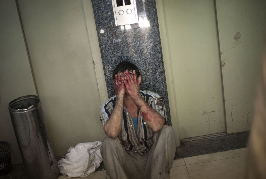 En man gråter i korridoren på sjukhuset Dar El Shifa i Aleppo, Syrien. Hans dotter blev träffad under en attack mot en skola i ett område där många flyktingar tagit skydd. Foto: Manu Brabo/AP Photo/TT.