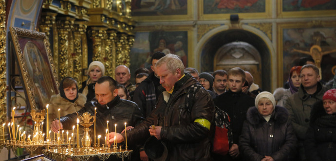 Ukrainian Orthodox believers light candles during the memorial service for the Heavenly hundreds in the Mikhaylivsky Cathedral in Kiev, Ukraine, Saturday, Feb. 20 2016. The "Heavenly Hundred" is what Ukrainians in Kiev call those who died during months of anti-government protests in 2013-14. (AP Photo/Sergei Chuzavkov)